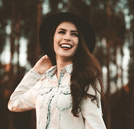 Woman smiling during a photoshoot in the forest.