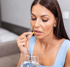 Woman taking supplement pill